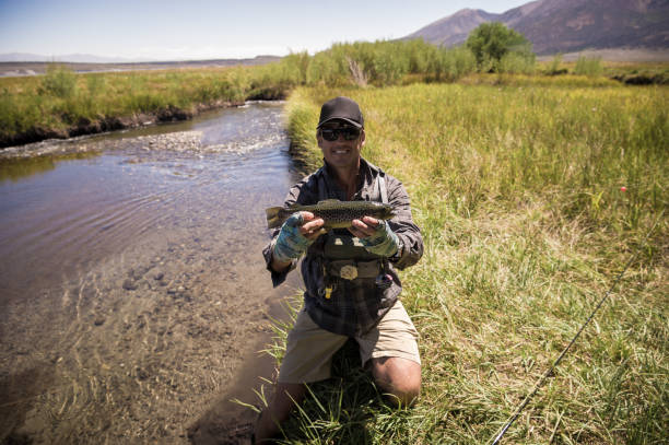 istock Fly Fisherman Showing Off His Catch 1042557880