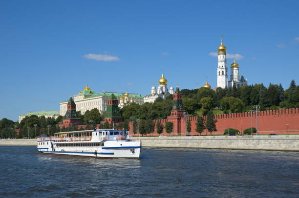 Summer view of the Moscow Kremlin and floating on the Moscow-river pleasure ship. Moscow, Russia Pleasure ship floats past the main landmark of Moscow - the Moscow Kremlin, Russia биткойн stock pictures, royalty-free photos & images