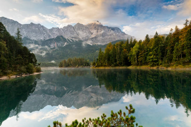 picco di montagna zugspitze mattina d'autunno sul lago eibsee vicino a garmisch partenkirchen. baviera, germania - zugspitze mountain lake autumn germany foto e immagini stock