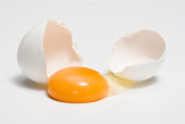 Broken eggshells next to egg yolk