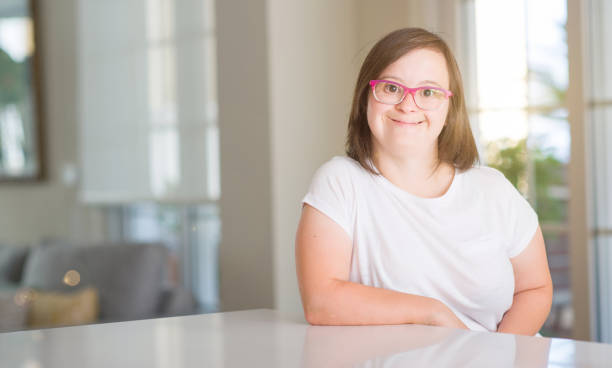 Down syndrome woman at home with a happy face standing and smiling with a confident smile showing teeth Down syndrome woman at home with a happy face standing and smiling with a confident smile showing teeth down syndrome photos stock pictures, royalty-free photos & images