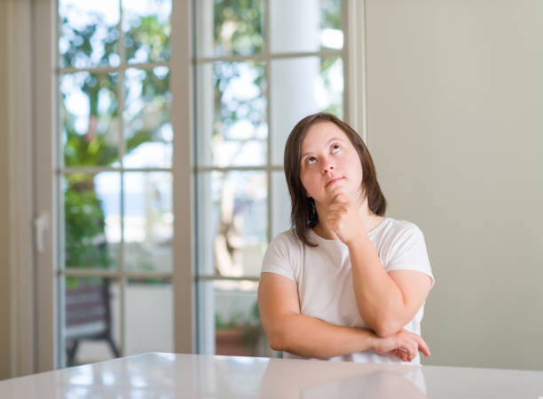 istock Down syndrome woman at home serious face thinking about question, very confused idea 1042580982