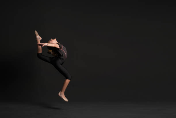 adolescente de atleta linda ginasta saltando no studio - gymnastics the splits teenage girls stretching - fotografias e filmes do acervo