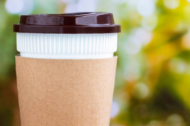 istock Paper coffee cup or disposable cup on the natural morning background with copy space for your text and logo. 1042584792