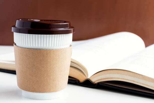 istock Paper coffee cup or disposable cup and book on the white table background with copy space for your text and logo. 1042584818