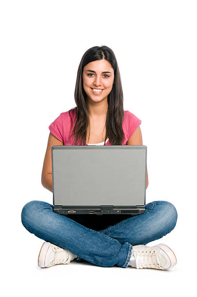 ragazza sorridente che lavora su un computer portatile - gambe incrociate foto e immagini stock