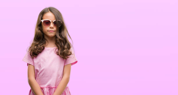istock Brunette hispanic girl wearing sunglasses with a confident expression on smart face thinking serious 1042593132