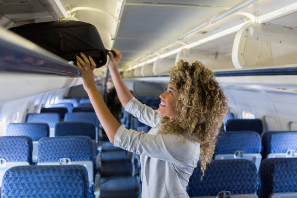 коммерческая авиакомпания пассажирских магазинов багажа накладные расходы - people traveling cabin baggage tourist curly hair стоковые фото и изображения