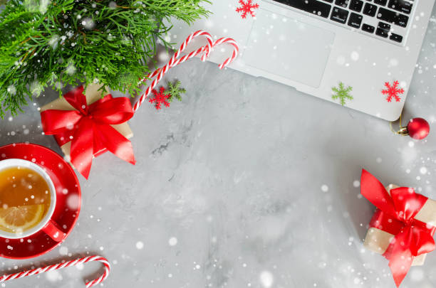 istock Christmas work space with laptop and red cup of hot tea. 1042603022