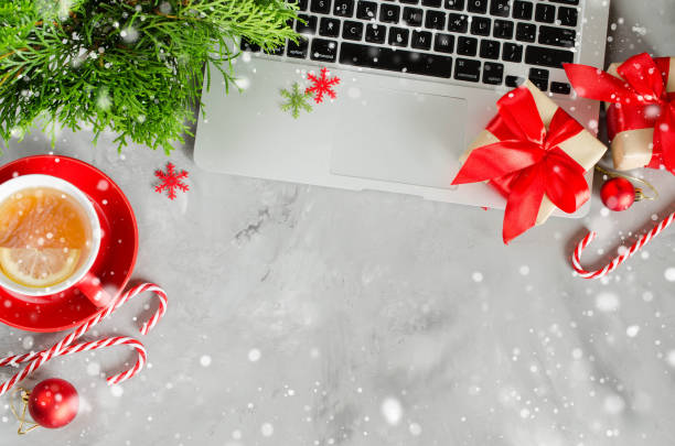istock Christmas work space with laptop and red cup of hot tea. 1042603074