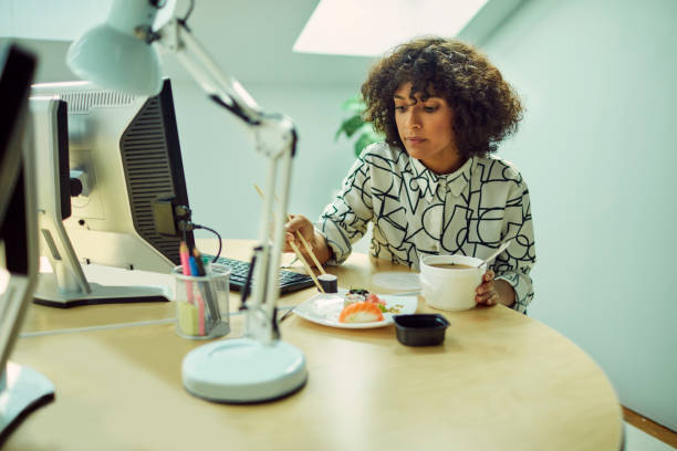istock Businesswoman Eating in Her Office 1042603150