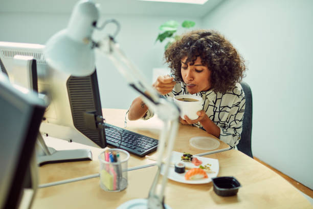 istock Businesswoman Eating in Her Office 1042603202