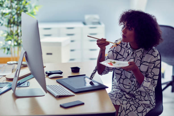 istock Businesswoman Eating in Her Office 1042603246