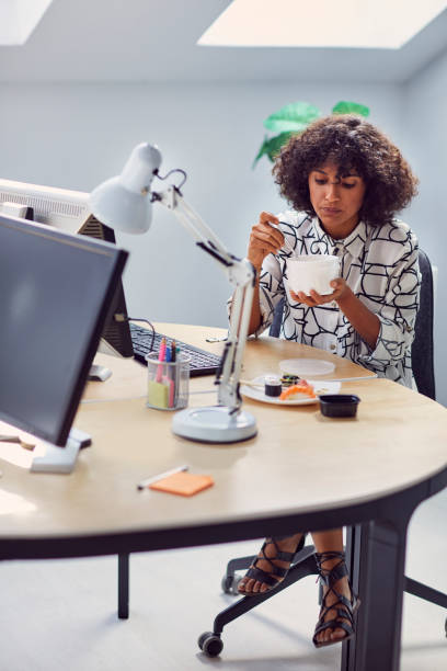 istock Businesswoman Eating in Her Office 1042603334