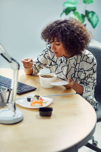 istock Businesswoman Eating in Her Office 1042603344