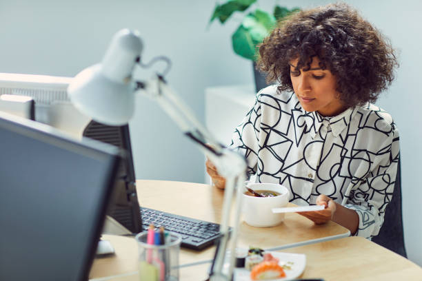 istock Businesswoman Eating in Her Office 1042603354