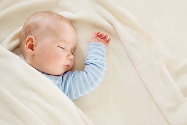 柔らかい白い毛布で覆わ�れて眠っている赤ちゃん - beautiful one person innocence lifestyles ストックフォトと画像