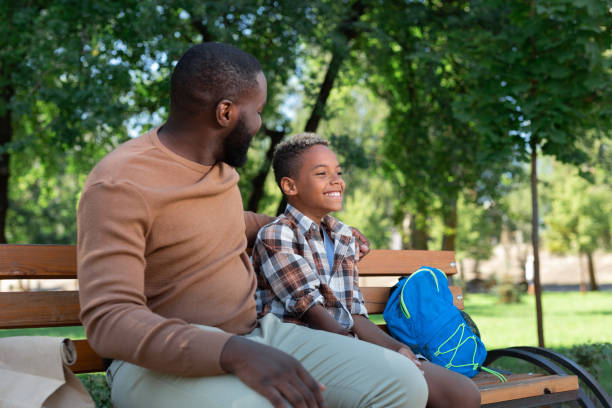 istock Delighted nice father and son sitting on the bench 1042610422