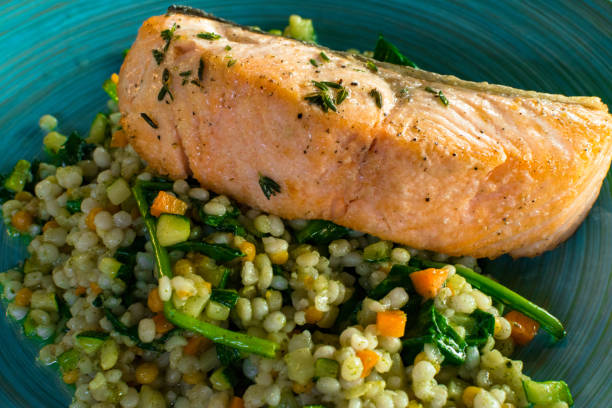 istock Barley salad assorted vegetables and salmon in plate in restaurant 1042611616