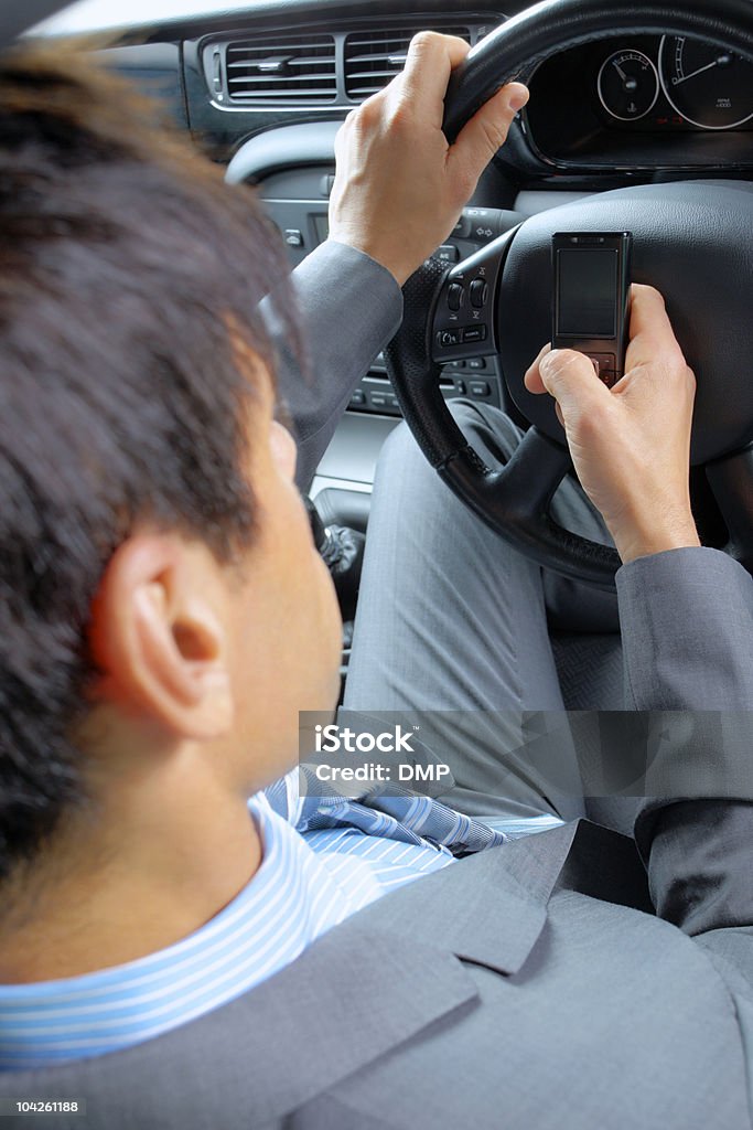 Homem de negócios usando o celular enquanto estiver dirigindo - Foto de stock de A caminho royalty-free