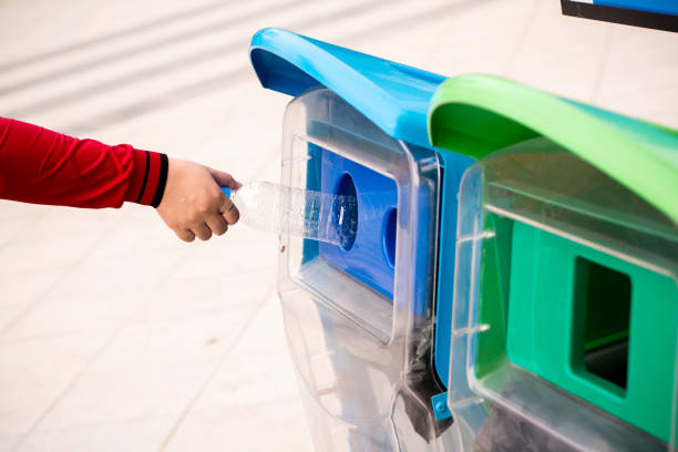 istock Close up Selective focus hand throwing empty plastic bottle into the trash.Woman hand putting empty plastic bottle in recycling bin. 1042635964