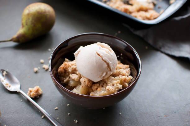 Pear crumble with pear ice cream in a bowl stock photo