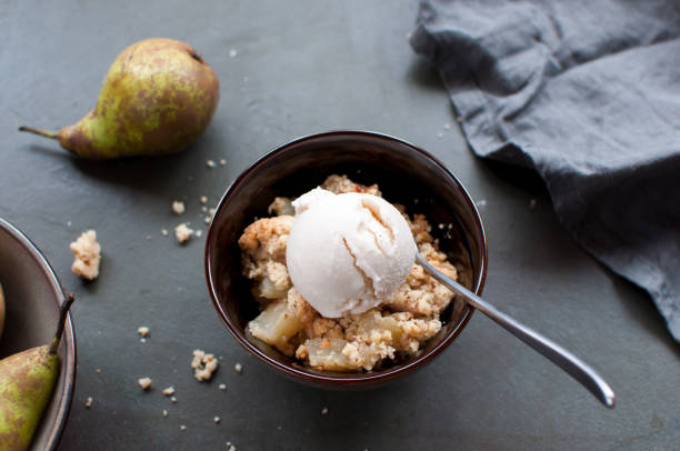Pear crumble with pear ice cream in a bowl stock photo