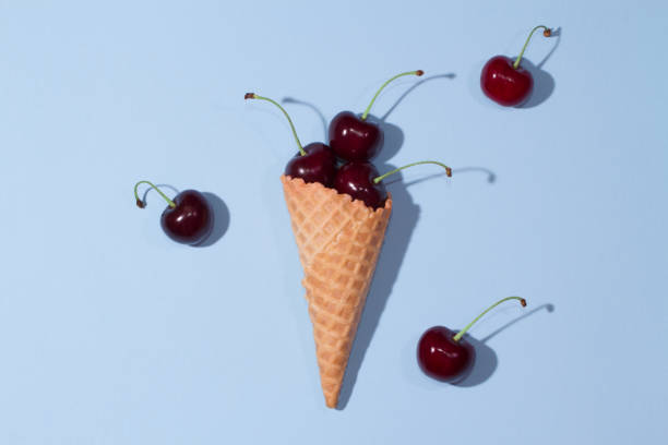 istock Cherries in an ice cream cone on a table on a blue background. 1042647766