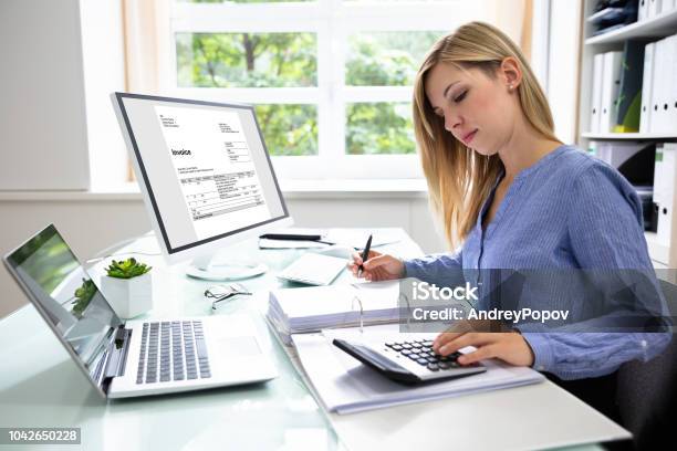 Young Businesswoman Calculating Bill In Office Stock Photo - Download Image Now - Financial Advisor, Accountancy, Office