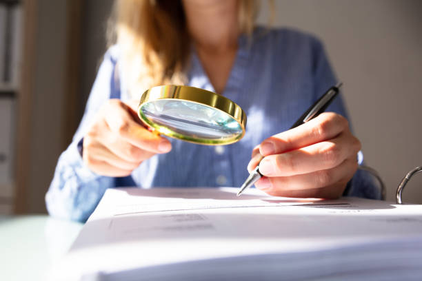 istock Businesswoman Checking Invoice With Magnifying Glass 1042650272