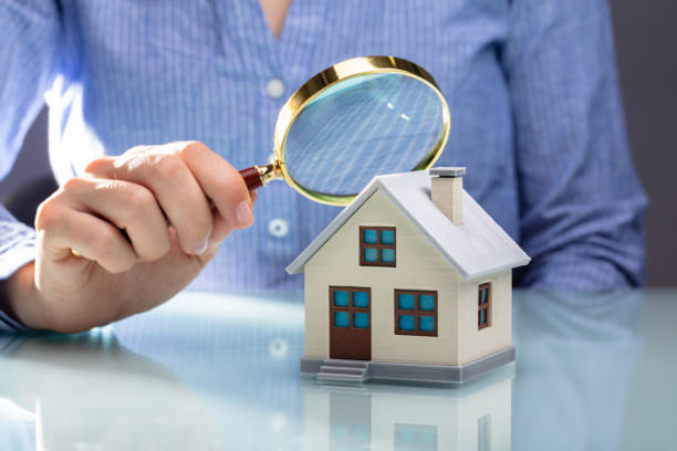 Businesswoman Holding Magnifying Glass Over House Model Close-up Of A Businesswoman's Hand Holding Magnifying Glass Over House Model Over Desk examining stock pictures, royalty-free photos & images