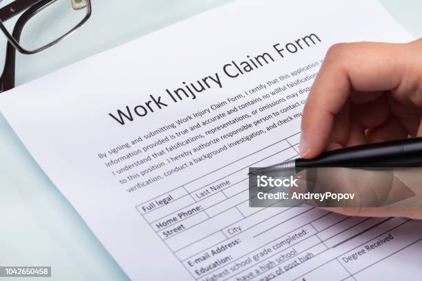 Woman Filling Work Injury Claim Form Stock Photo - Download Image Now - Occupation, Physical Injury, Satisfaction