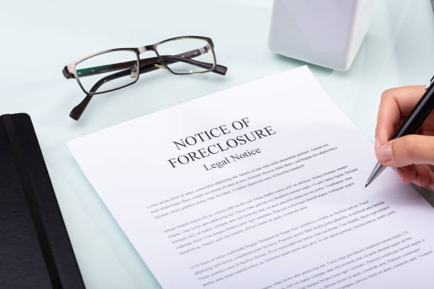 Woman Holding Pen Over Notice Of Foreclosure Document Close-up Of A Woman's Hand Holding Pen Over Notice Of Foreclosure Document foreclosure stock pictures, royalty-free photos & images