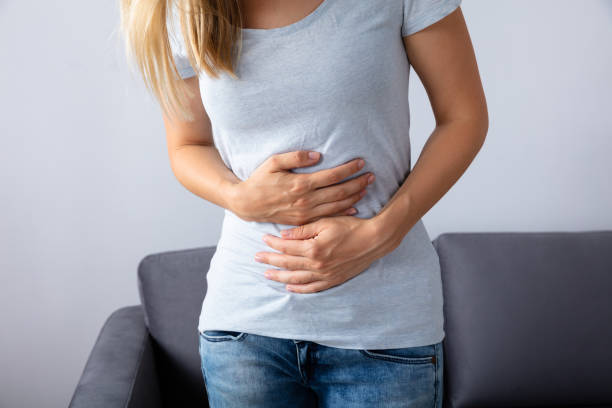 mujer que sufre de dolor de estómago - belly ache fotografías e imágenes de stock