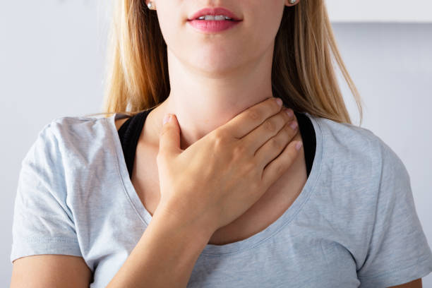 mujer que tiene dolor de garganta - touching neck fotografías e imágenes de stock