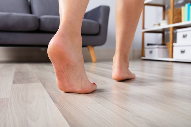 piede della donna che cammina sul pavimento in legno - barefoot foto e immagini stock