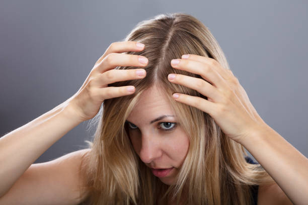 istock Woman Examining Her Hair 1042651462