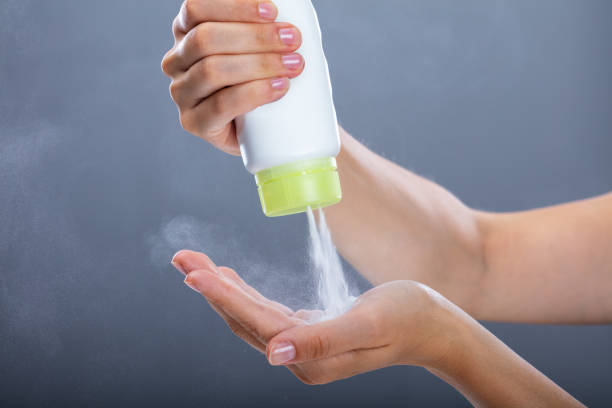 woman using talcum powder - moisturizer cosmetics merchandise human hand imagens e fotografias de stock