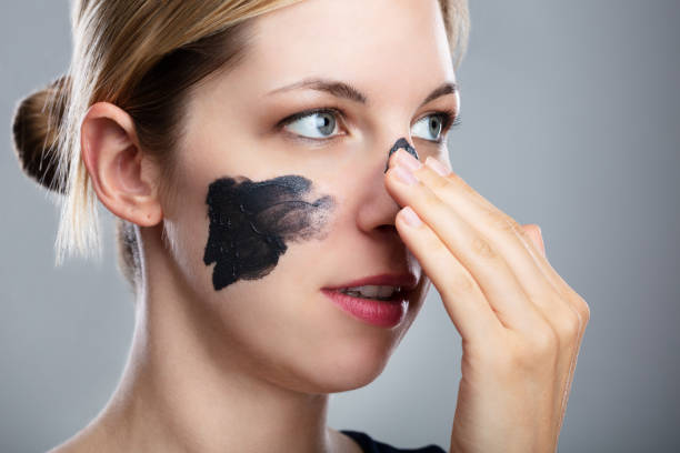 istock Woman Applying Activated Charcoal Mask On Her Face 1042651566