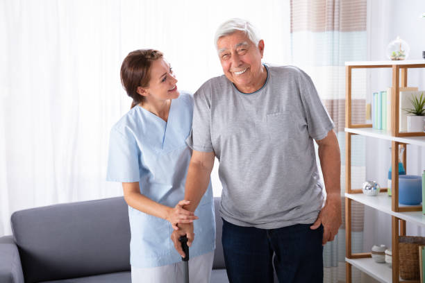 istock Caretaker Assisting Senior Man While Walking At Home 1042652380