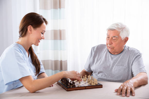 istock Female Caretaker Playing Chess With Senior Man 1042652424