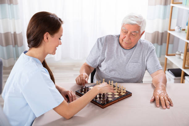 istock Female Caretaker Playing Chess With Senior Man 1042652426
