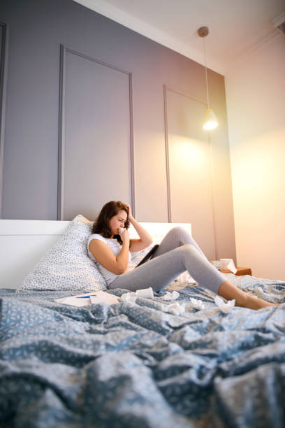 istock Middle age woman sitting in her bed and feeling sick. 1042652694