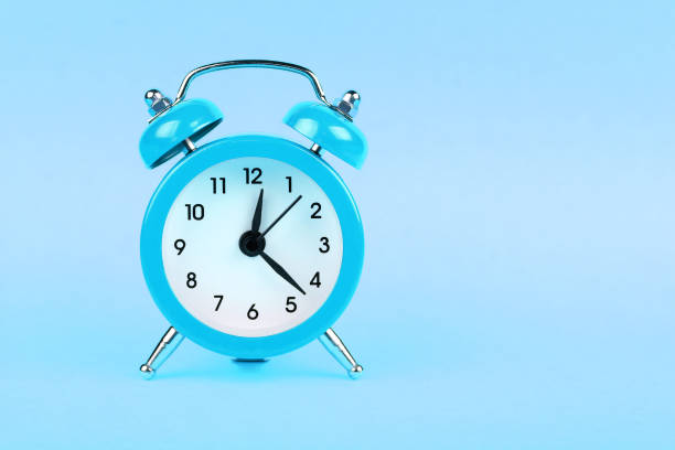 istock Close up one blue alarm clock on pastel background 1042658024