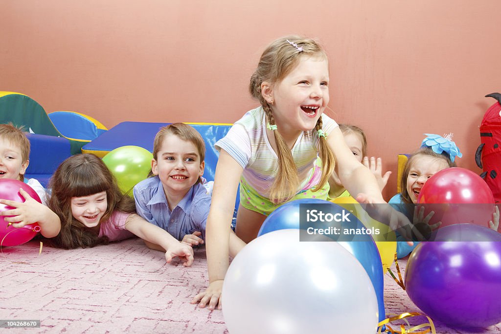 Happy kids playing with balloons A group of happy kids playing with colorful balloons Balloon Stock Photo