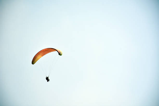 istock Paraglider on a clear day for background usage. Spaces for type. 1042689144