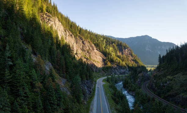 Scenic Highway in British Columbia Striking aerial panoramic landscape view of a scenic road in the valley surrounded by the beautiful Canadian Mountains. Located near Revelstoke, BC, Canada. revelstoke stock pictures, royalty-free photos & images