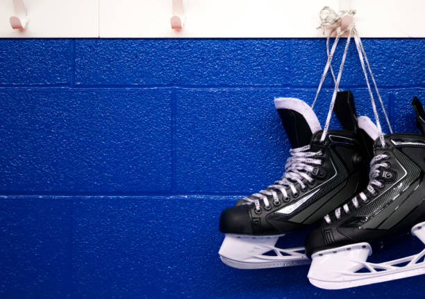 istock Hockey skates hanging over blue wall with copy space 1042700300
