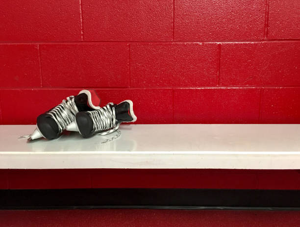 hóquei patins no banco branco no vestiário com espaço vermelho de fundo e cópia - ice hockey ice team canada - fotografias e filmes do acervo