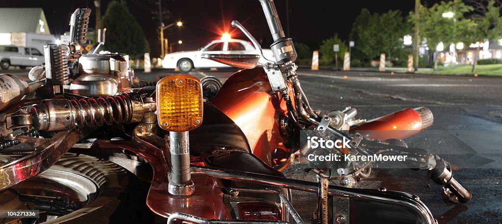 Close up photograph of a crashed motorcycle and police car View from the rear of a wrecked motorcycle looking towards an out of focus police vehicle.More of my car accident photos. Motorcycle Stock Photo